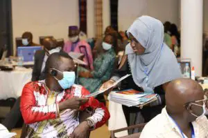 Participants masqués en discussion lors de la conférence régionale sur les droits d'accises sur le tabac