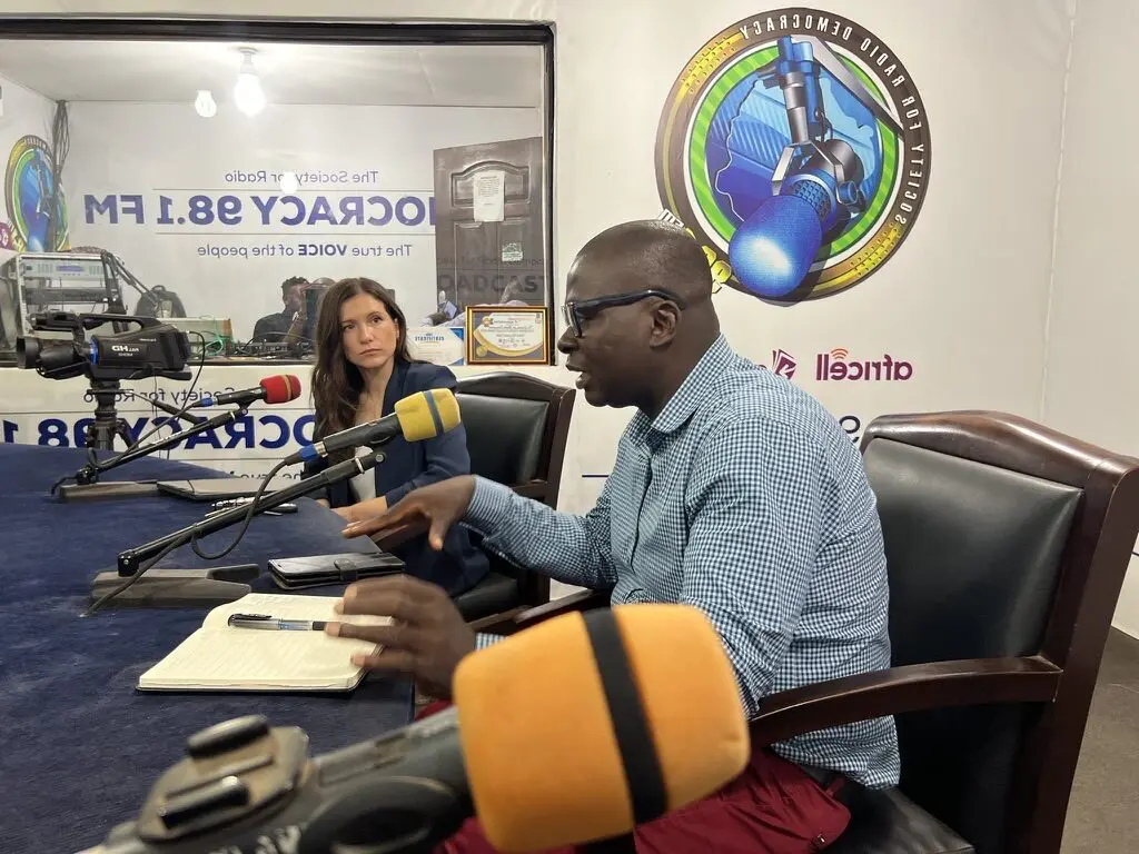 Deux invités au micro dans le studio de Radio Democracy 98.1 FM