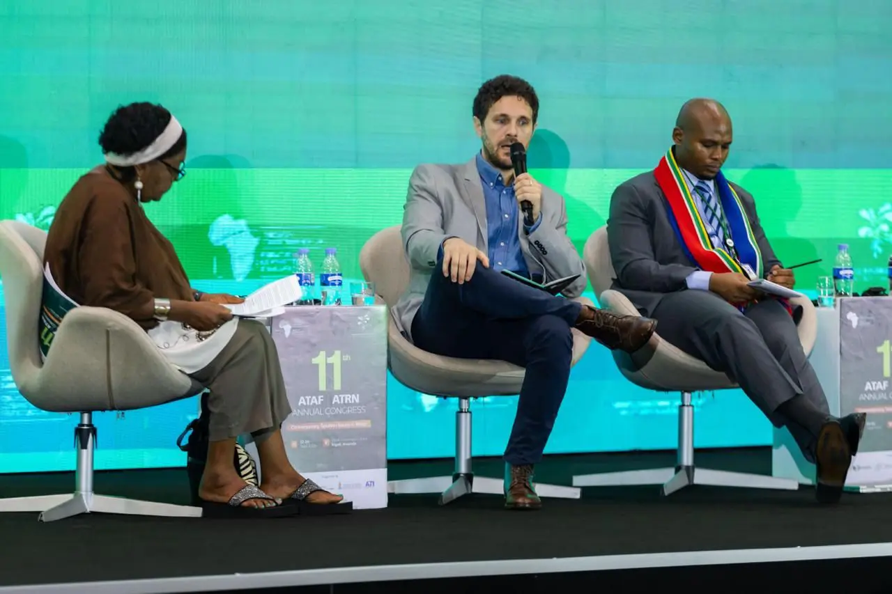 Trois intervenants assis sur scène, sur fond vert, à l'ATRN 2026. Au centre, Fabrizio Santoro, ICTD. 