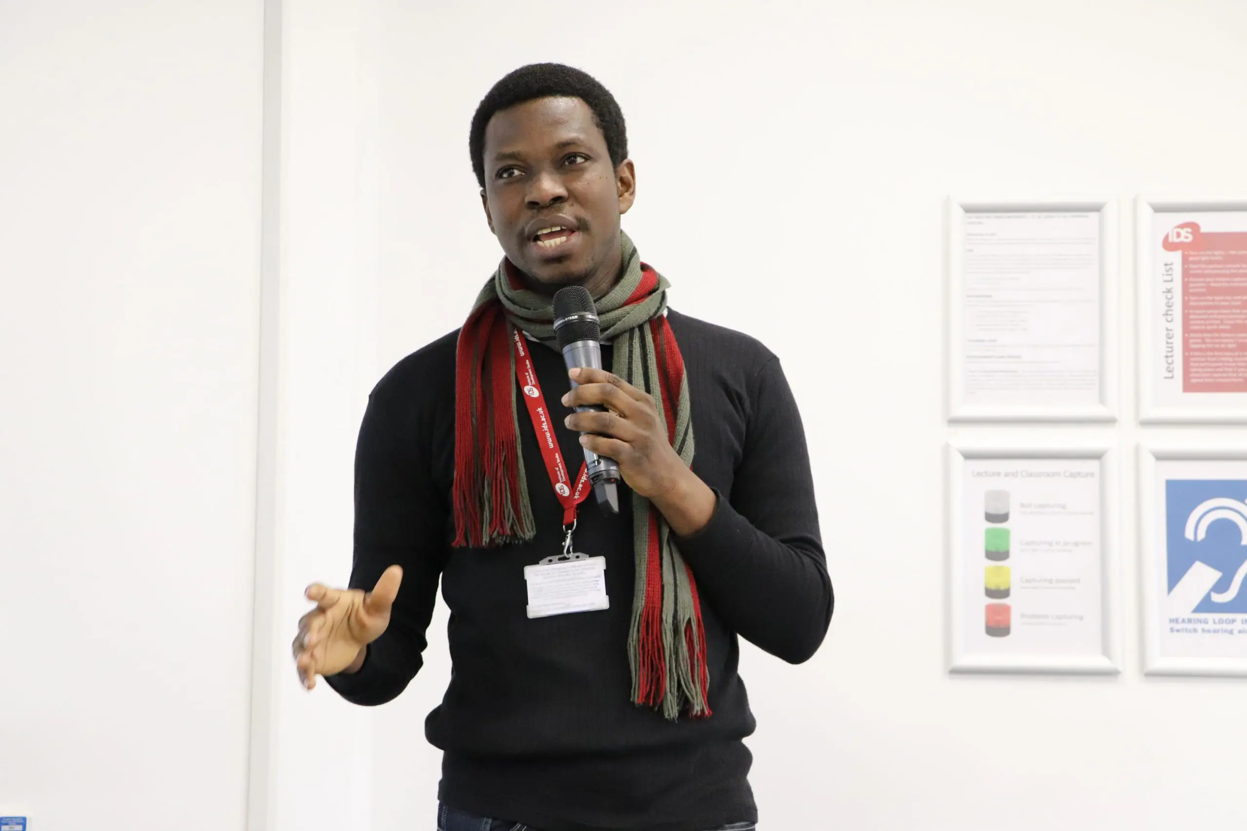 A Visiting Fellow speaking into a microphone at IDS