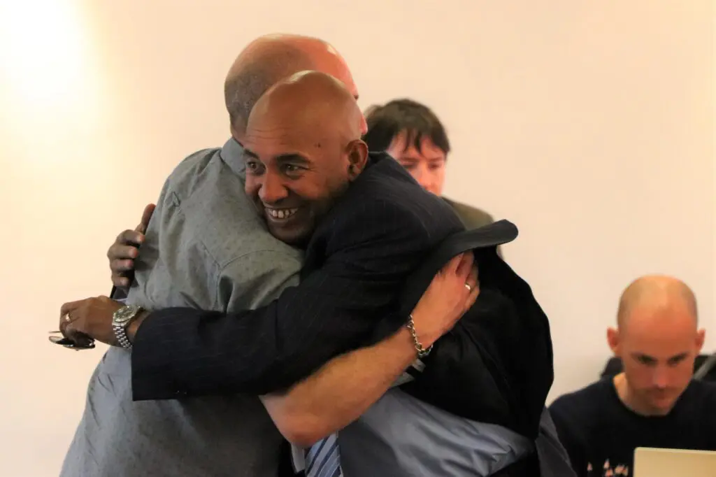 Two workshop participants embracing