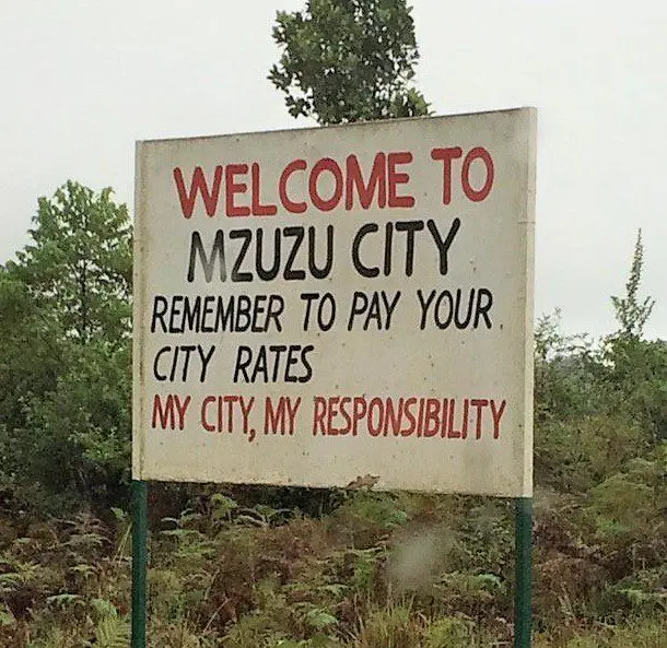 Roadside sign: Welcome to Mzuzu City, remember to pay your city rates