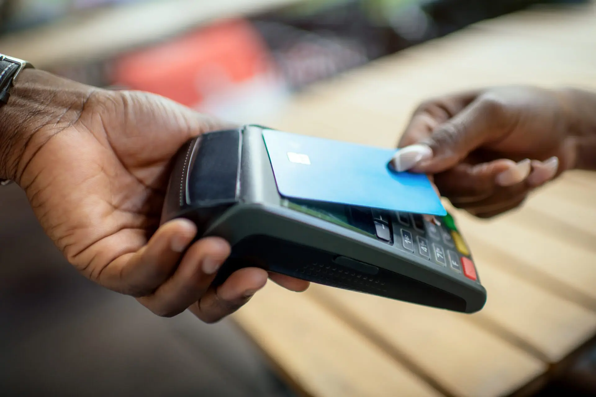 Young African woman paying with credit card in a cafe. Credit. ArtMarie