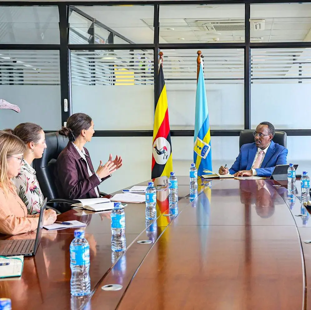 Réunion à l'Uganda Revenue Authority, avec les drapeaux de l'Ouganda et de l'URA à côté de la table de conférence