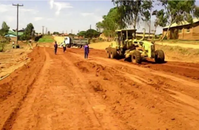 Niveleuse aplanissant une route en terre à Mzuzu
