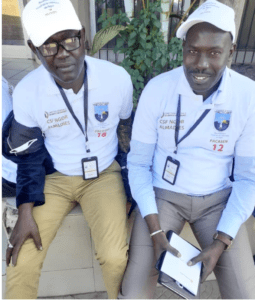 Deux agents fiscaux en casquette et chasuble lors d'un recensement foncier à Ngor-Almadies, au Sénégal