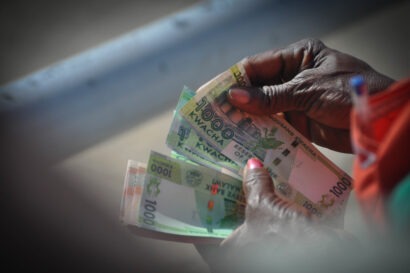 Close up shot on a pair of hands holding a stack of Malawian Kwacha