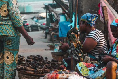 Woman Sitting and Working at Market on Street